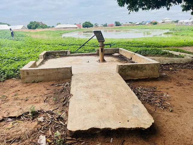 Villagers collecting water from a hand pump