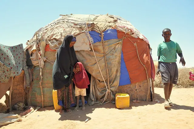 A mother and child sitting together outside their home