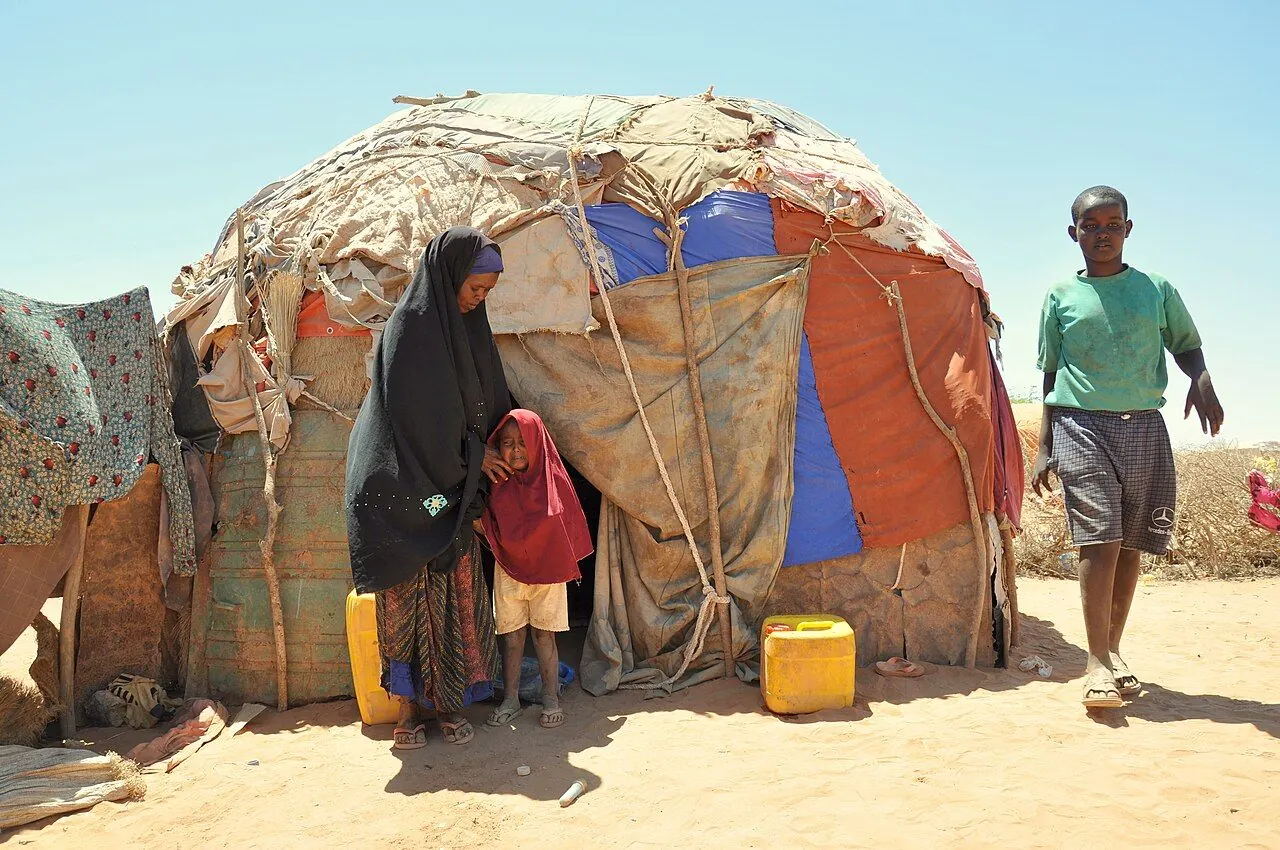 A mother and child sitting together outside their home